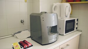 A kitchen with a coffee maker, microwave, and a tray of Lipton tea packets. - Holiday Sunny Roma B&B (Rome)