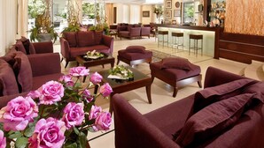 A spacious lobby with multiple seating areas, a bar, and a reception desk.
