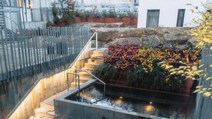 A staircase leading to a rooftop garden with a water feature and a view of the cityscape. - Miðgarður by Center Hotels (Reykjavik)