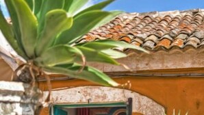 A building with a tiled roof, a door with a red curtain, and a framed picture on the wall. - Tenuta di Roccadia (Carlentini)