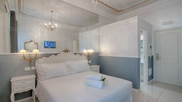 Une chambre à coucher avec un grand lit, des tables de chevet, un miroir et un lustre.