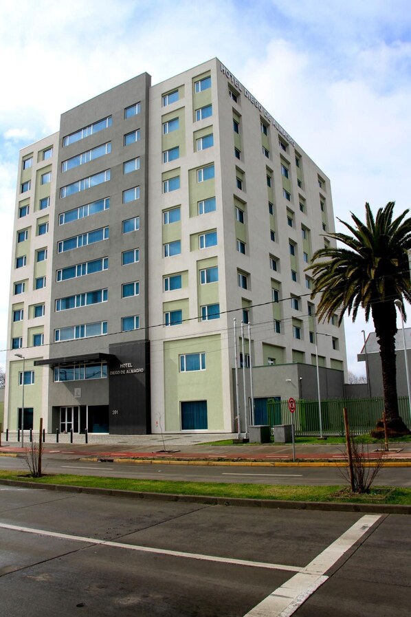 Een hotel met meerdere verdiepingen, modern vormgegeven, met een vlakke gevel en tal van ramen.