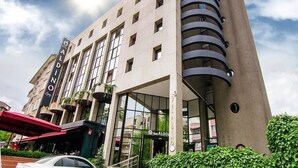 A modern hotel with a prominent curved tower, large windows, and a visible entrance. - Aldino Hotel & Spa (Ankara)