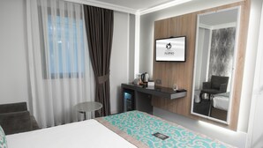A hotel room with a bed, a small table, a TV, a mirror, and a window with curtains. - Aldino Hotel & Spa (Ankara)