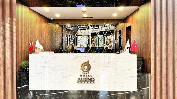 A hotel reception desk with a marble top and a logo. - Aldino Hotel & Spa (Ankara)