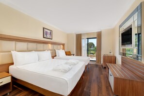 A hotel room with two beds, a TV, a desk, and a balcony with a view. - Oz Hotels İncekum Beach Resort (Alanya)