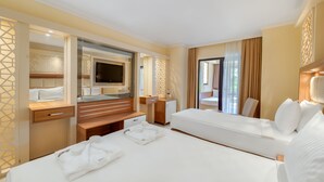 Una habitación de hotel con dos camas, televisor, escritorio y baño.