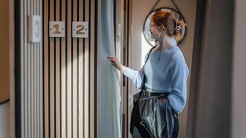 A person standing at a door with numbers 1 and 2 on it, indicating room numbers.