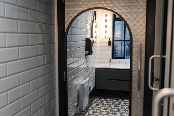 A narrow hallway with a tiled wall, a window, and a sink area. - CODE - The Loft, Edinburgh (Edinburgh)