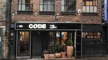 A storefront with a black awning labeled 'CODE THE LOFT' and a sign indicating the number '50'.