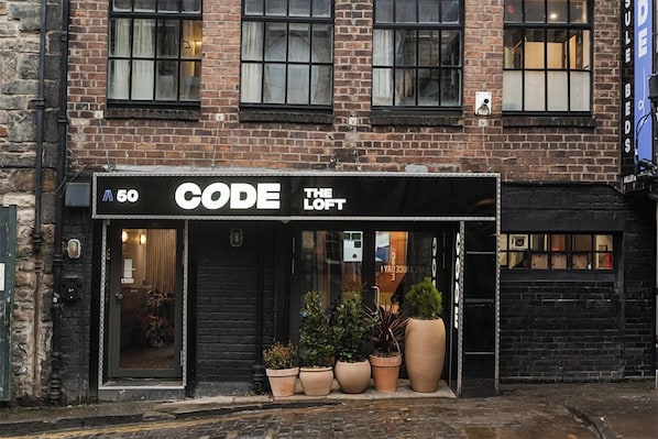 A storefront with a black awning labeled 'CODE THE LOFT' and a sign indicating the number '50'.