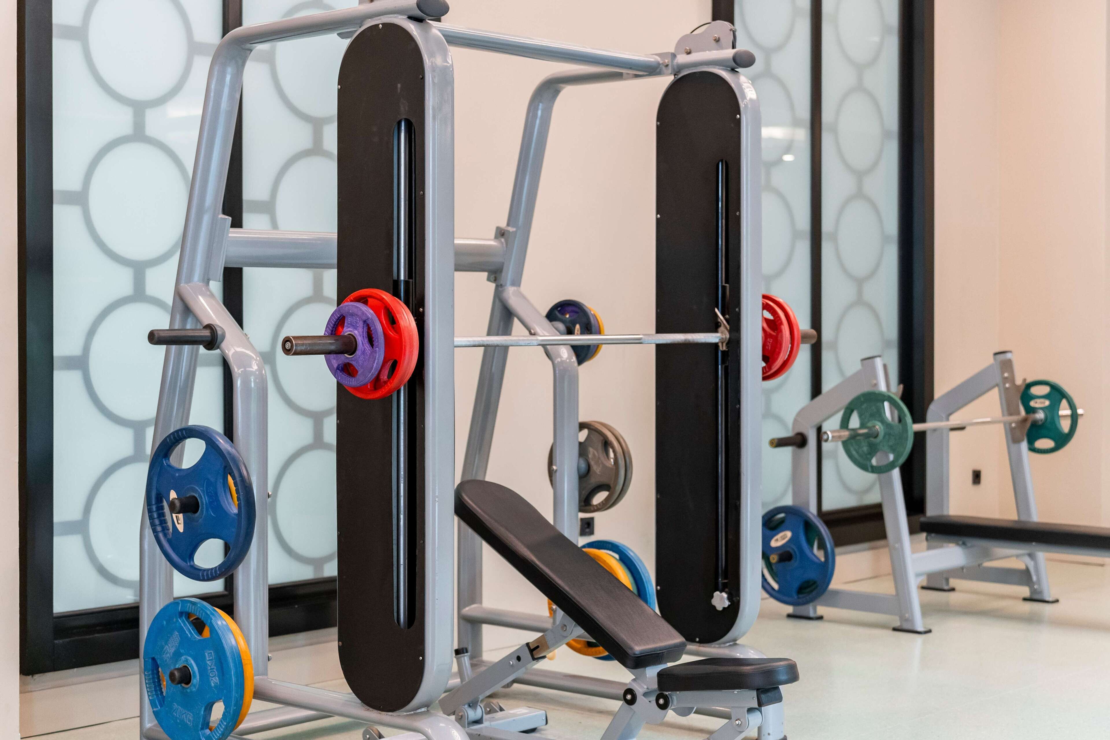 A weightlifting station with adjustable benches and a variety of weight plates.