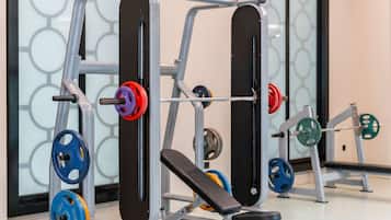 A weightlifting station with adjustable benches and a variety of weight plates.