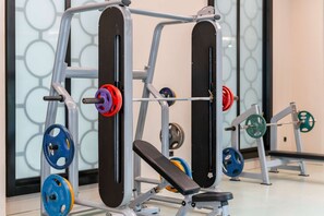 A weightlifting station with adjustable benches and a variety of weight plates. - Oz Hotels Side Premium (Manavgat)