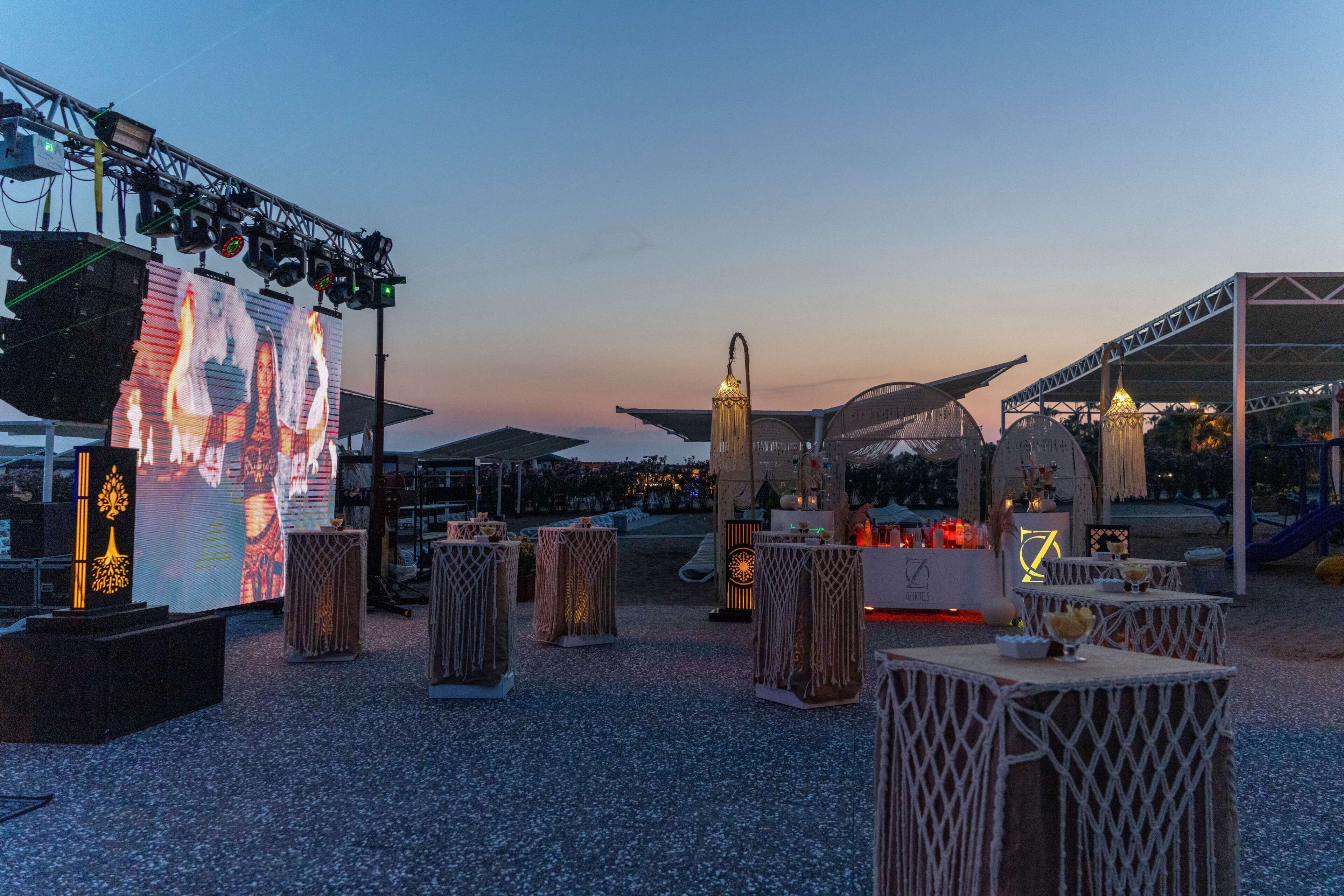 An outdoor event space with a stage, seating areas, and a tent structure.