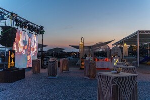 An outdoor event space with a stage, seating areas, and a tent structure. - Oz Hotels Side Premium (Manavgat)