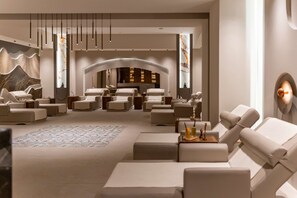 A modern lounge area with multiple seating options, a fireplace, and a large mirror. - Oz Hotels Side Premium (Manavgat)