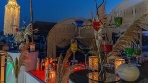 A bar area with multiple glasses of various beverages, a decorative light fixture, and rustic decor elements. - Oz Hotels Side Premium (Manavgat)