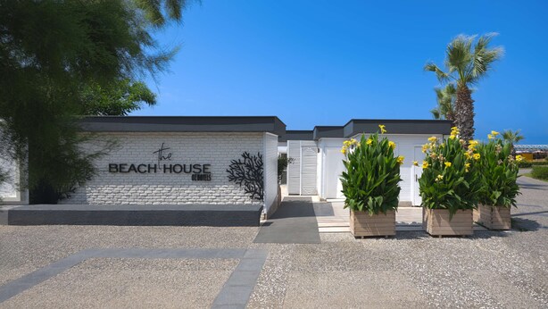 A building labeled 'The Beach House' with a gravel driveway and potted plants. - Oz Hotels Side Premium (Manavgat)
