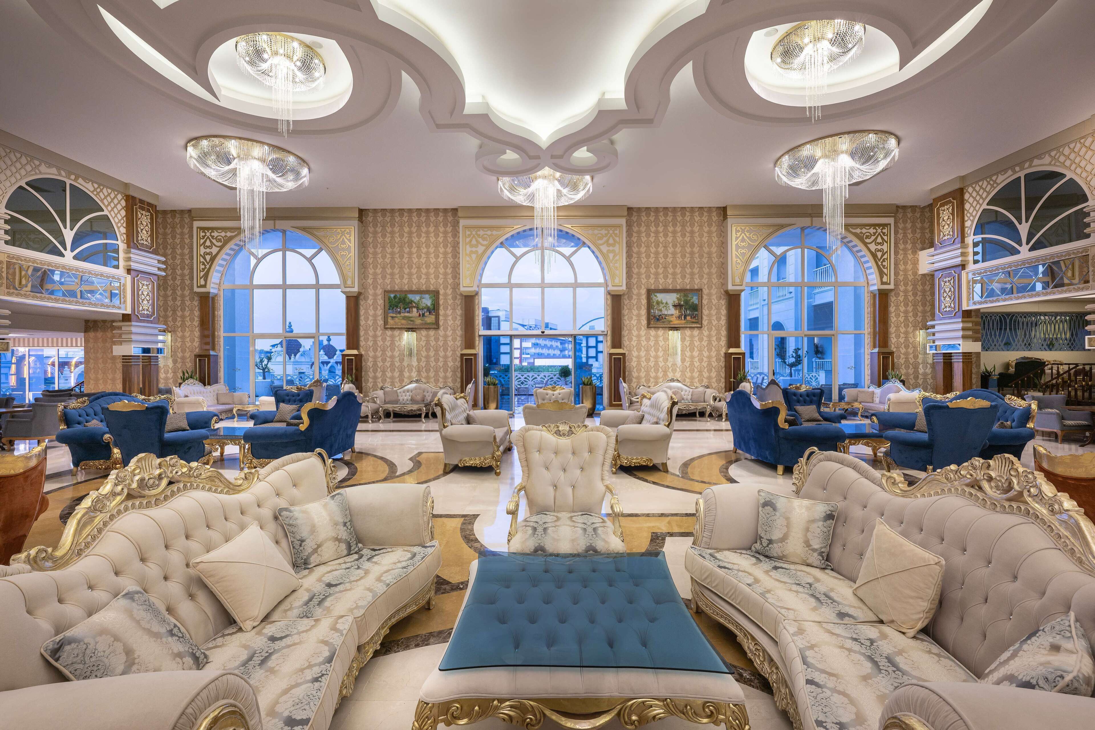A luxurious lobby with ornate chandeliers, elegant seating, and large windows offering a view.
