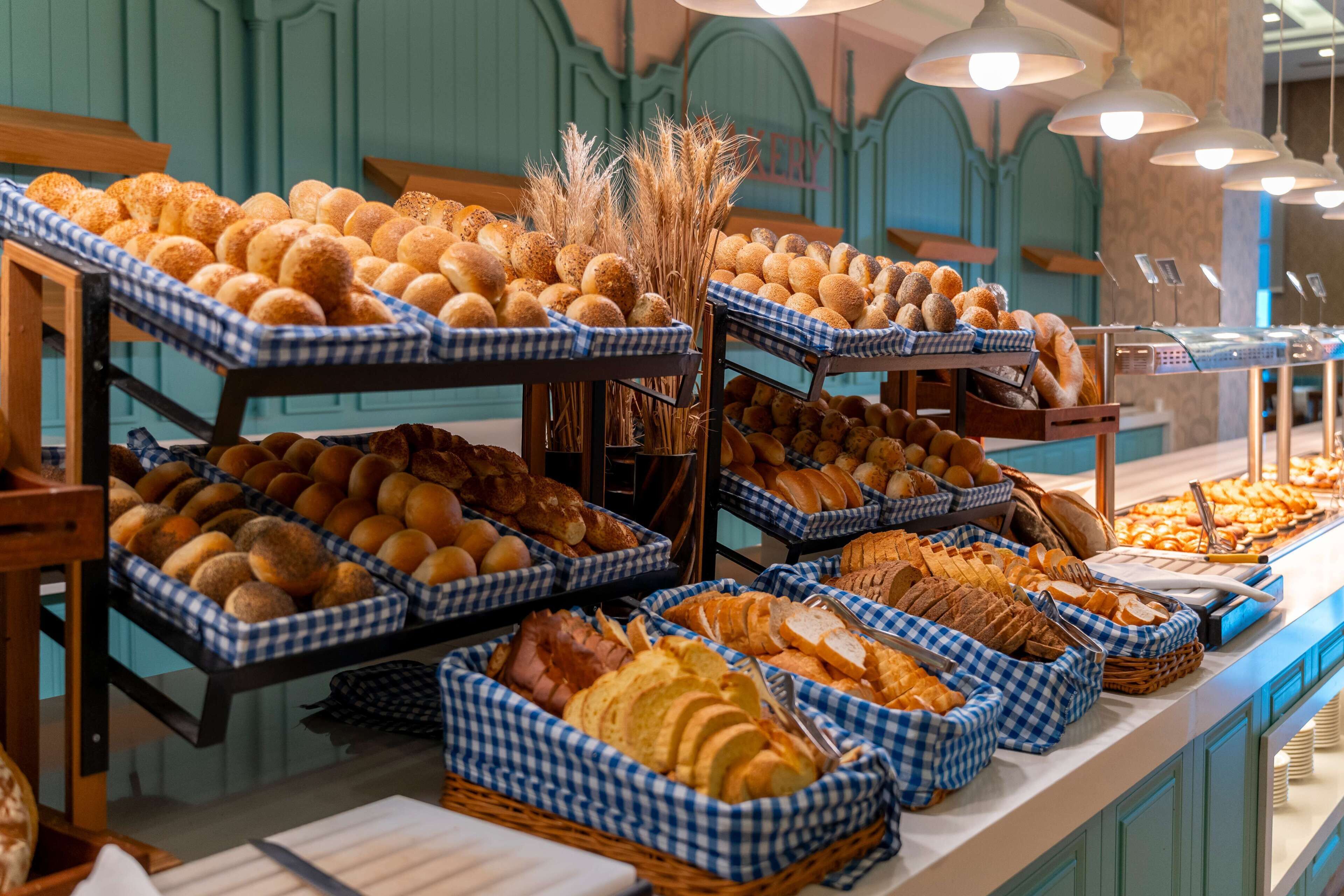 A buffet with various breads and pastries displayed in checkered baskets.