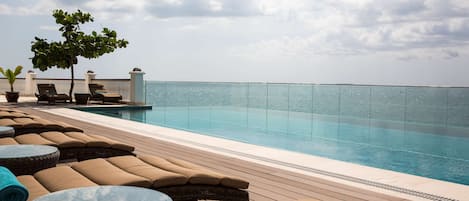 Piscine extérieure, parasols de plage, chaises longues