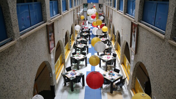 Ein geräumiger Korridor mit Tischen und Stühlen, dekoriert mit hängenden Laternen und Ballons.