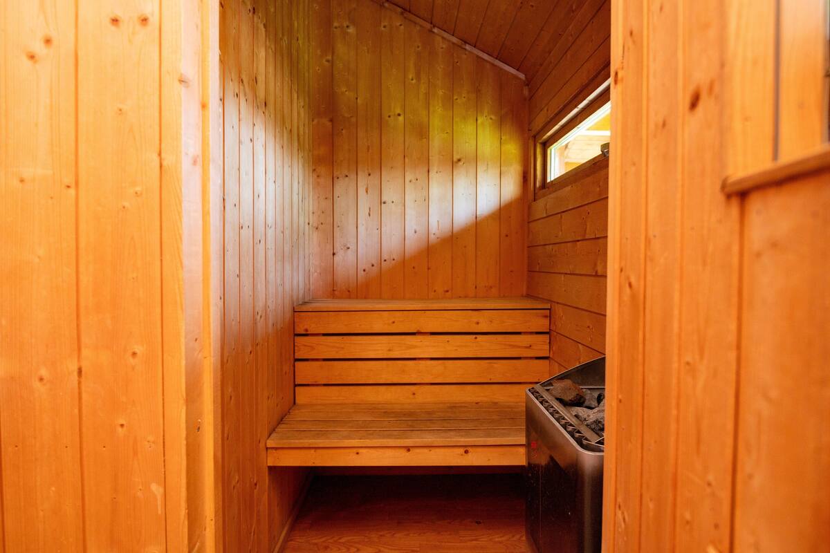 A sauna with wooden benches and a steam generator.