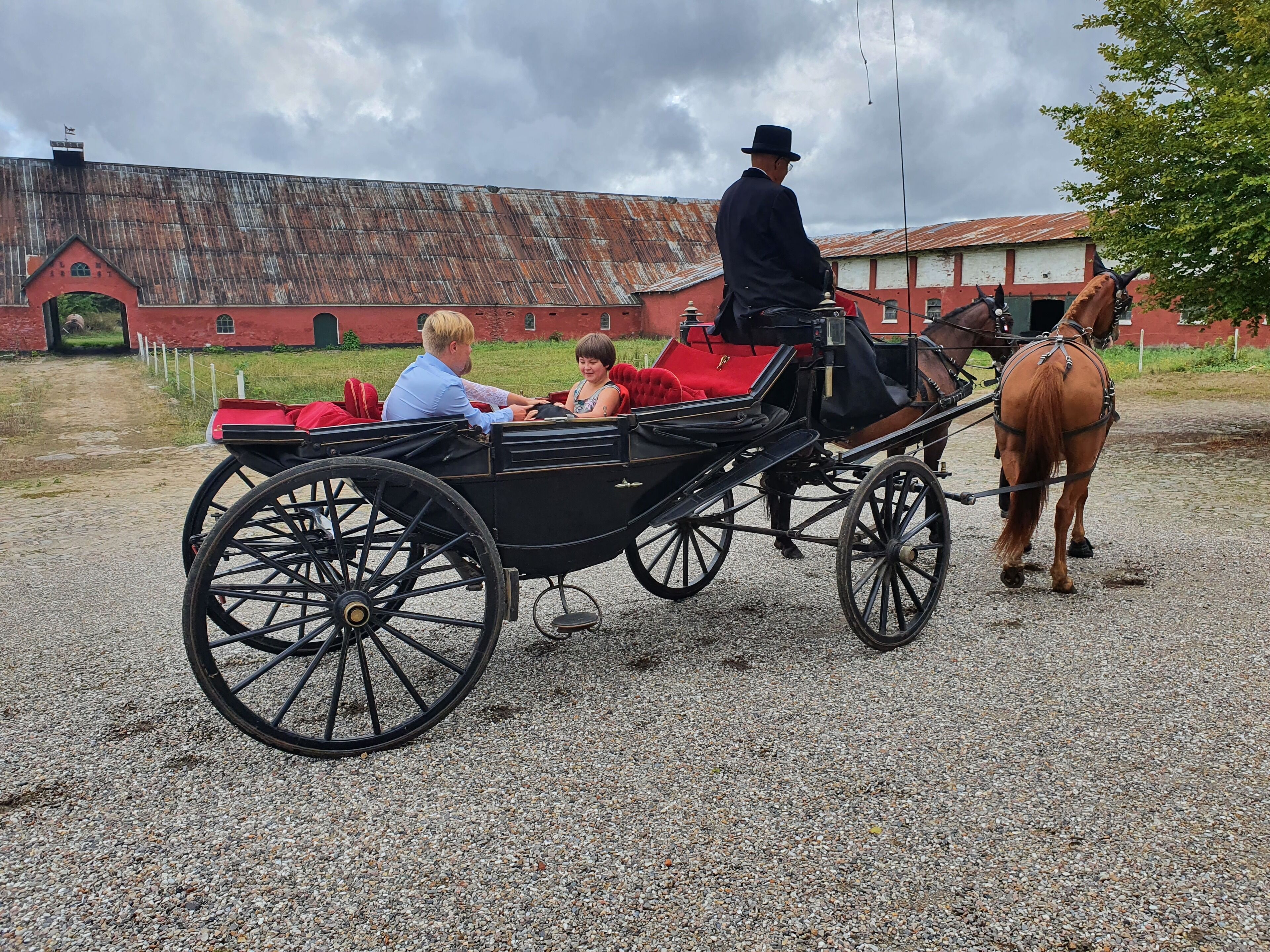 Un carruaje tirado por caballos con pasajeros y un caballo.