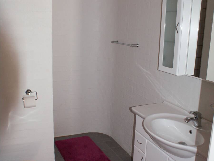 A bathroom with a toilet, sink, and mirror.