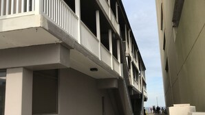 Un edificio de varios pisos con balcones y una escalera central.