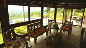 A wooden-furnished outdoor seating area with a view of a lush landscape. - Finca Hotel La Tata Premium (Montenegro)