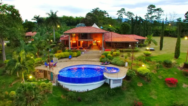 A large house with a swimming pool, surrounded by lush greenery and a well-maintained garden. - Finca Hotel La Tata Premium (Montenegro)
