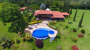 A large house with a swimming pool, surrounded by well-maintained gardens and tall trees. - Finca Hotel La Tata Premium (Montenegro)