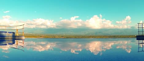 Una piscina al aire libre, sombrillas, tumbonas