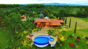 A large house with a swimming pool, surrounded by lush greenery and a well-maintained lawn. - Finca Hotel La Tata Premium (Montenegro)