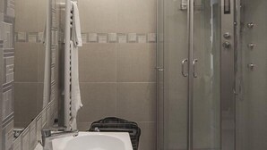 A modern bathroom with a glass-enclosed shower, a large sink, and a towel rack.