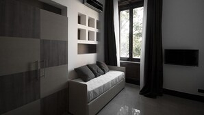 A modern room with a built-in sofa, a flat-screen TV, and a large window with curtains.