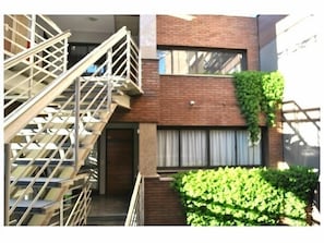 A multi-story building with a staircase and a brick facade.