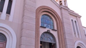Una iglesia con una amplia entrada en arco, varias ventanas y un campanario.