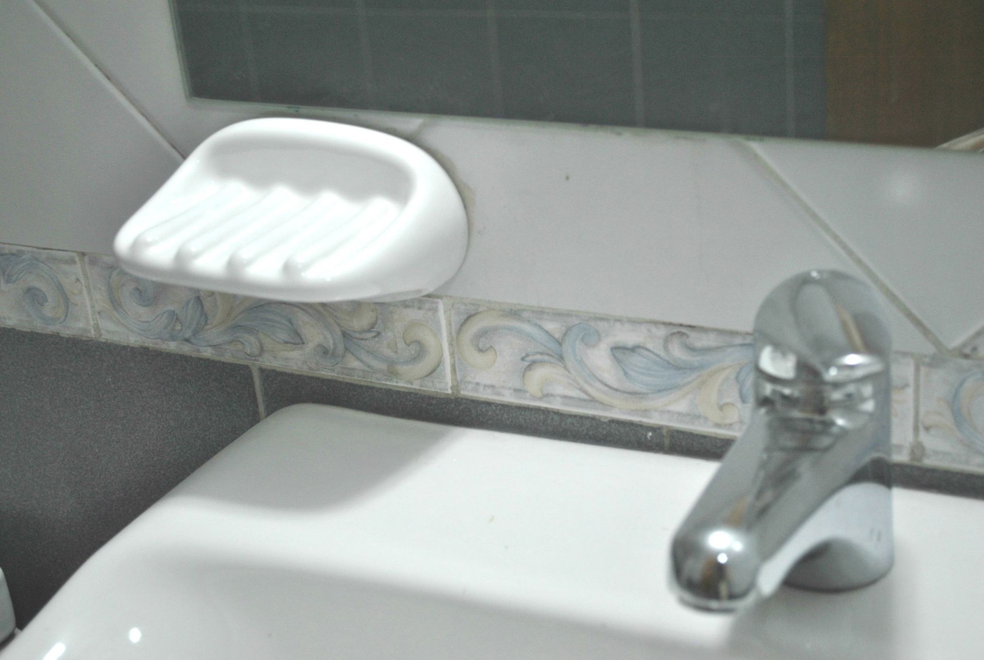 Een wastafel met een zeepbakje en een kraan.