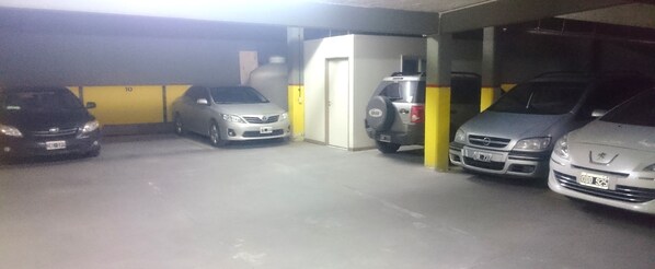 A parking garage with four cars parked in a row. - Apartamentos Mendoza (Mendoza)