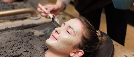 A person receiving a facial treatment with a mask applied to their face.