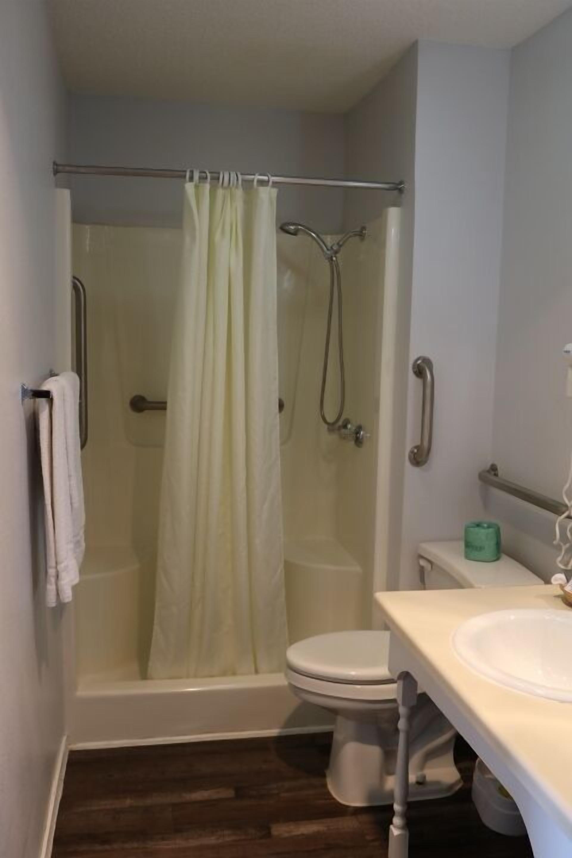 A bathroom with a shower, toilet, and sink.