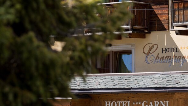 Een hotel genaamd 'Hotel Garni' met een bord waarop staat dat het een 'Hotel Champagn' is.