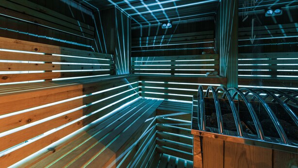 A sauna with wooden benches and a metal railing. - Hotel Steinbock (Livigno)