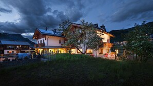 A large, two-story building with a sloped roof, multiple windows, and a balcony. - Hotel Steinbock (Livigno)