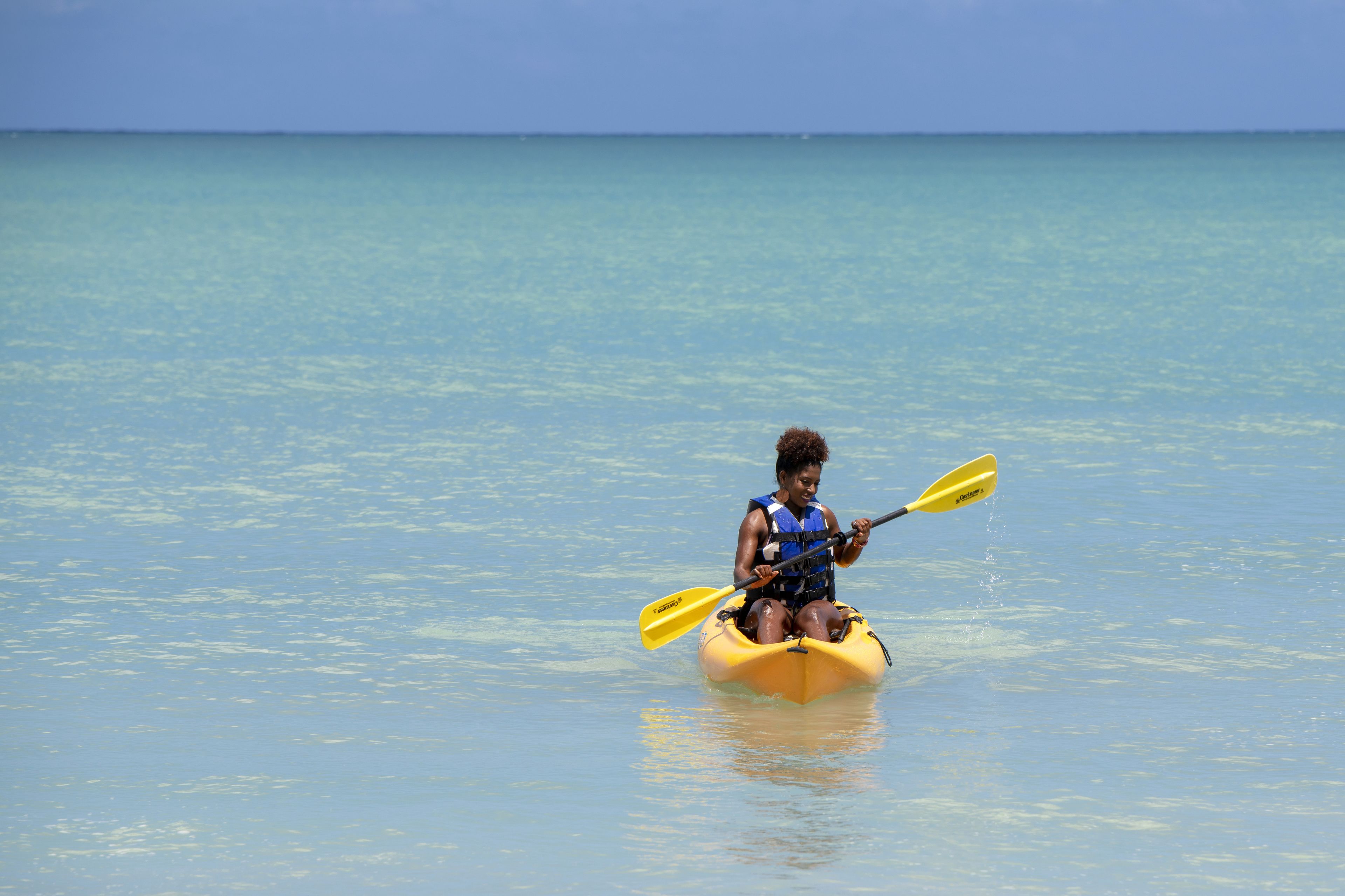 Uma pessoa a remar num mar calmo.