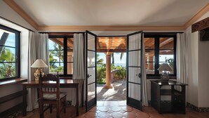 A room with a wooden desk, a chair, and a view of the ocean through open doors. - La Valise Los Cabos, Member of Small Luxury Hotels (Vinorama)
