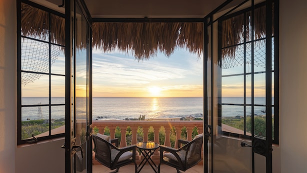 A room with a view of the sunset over the ocean, a glass door, and two chairs with a small table. - La Valise Los Cabos, Member of Small Luxury Hotels (Vinorama)